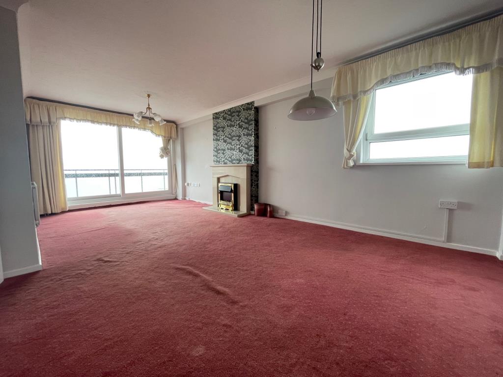 Lot: 137 - THREE-BEDROOM PENTHOUSE FLAT WITH COASTAL VIEWS - Living room with patio doors to balcony